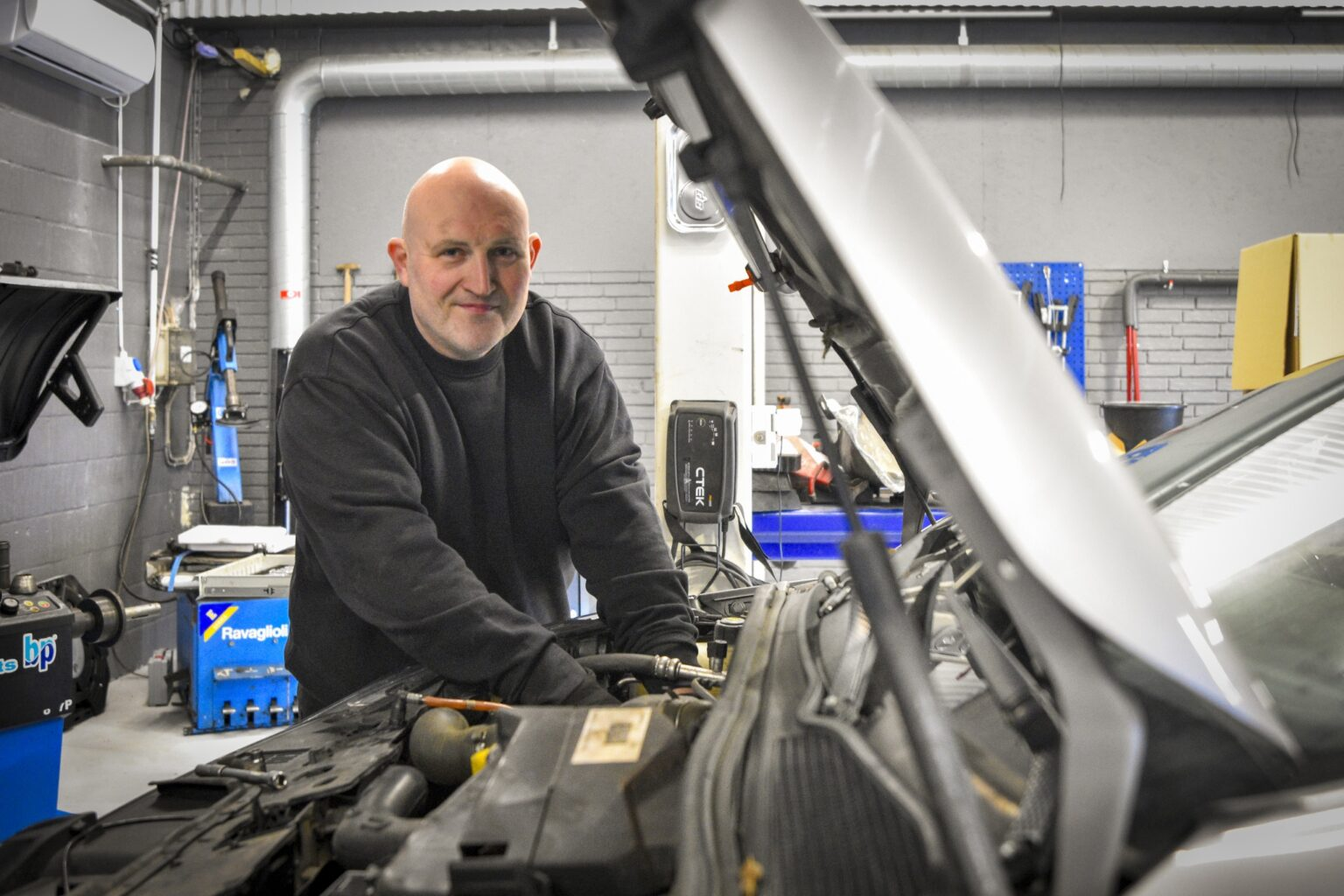 Rune Wiese arbejder under motorhjelmen i værkstedet hos RW Autoteknik Faaborg